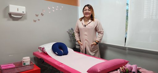 Dra. Anna Isabel Pinheiro do Carmo em seu consultório de atendimento pós-operatório acolhedor com maca terapêutica